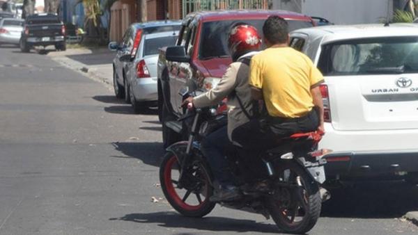 Dos hombres en una moto, situación que buscan prohibir por cuestiones de seguridad
